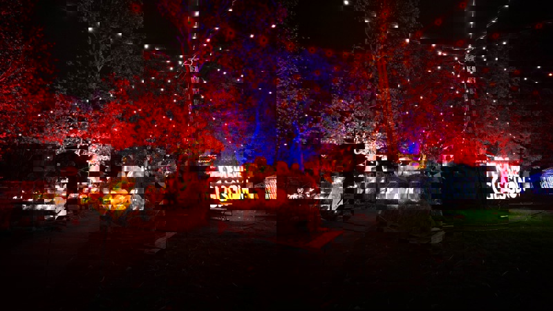 A night time scene of illuminated pumpkins and a light installation that reads "PEOPLE MAKE GLASGOW."