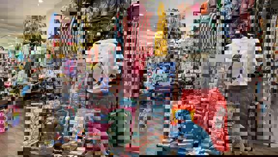 A display of eclectic items inside the Pink Poodle Boutique, including toys, books, and colourful clothing on mannequins.