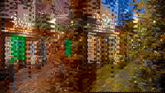 The Grosvenor Picture Theatre in Glasgow, adorned with Christmas lights and festive decorations, at dusk. A sign offers a "Festive Movie and a Meal."