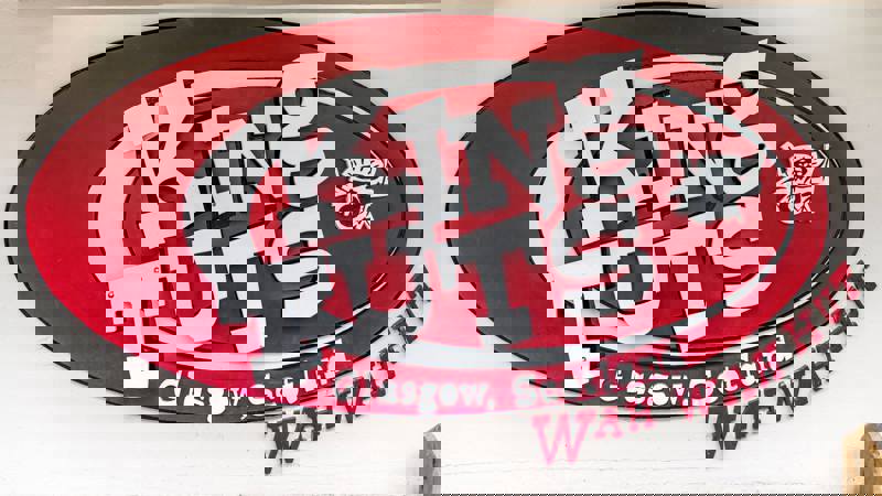 A red and white sign for "King Tut's Wah Wah Hut" is mounted on a building.