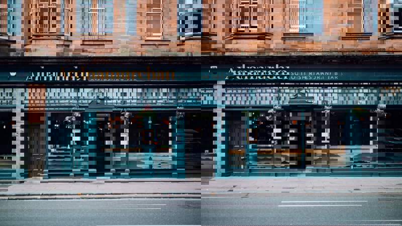 The street-level exterior of Ardnamurchan Scottish Restaurant & Bar, with a dark teal storefront and gold lettering on a sandstone building.