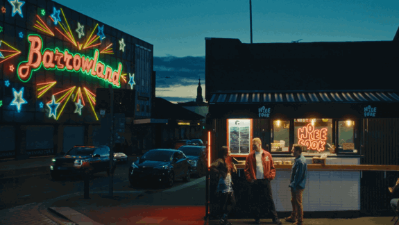  Neon-lit night scene: Barrowland sign with stars, a takeaway shop (Ho Lee Fook) on the right, and three people talking outside in Glasgow, Scotland.