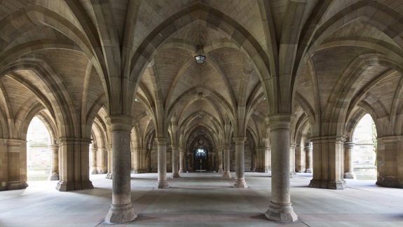 A majestic, arched stone cloister at the University of Glasgow, with light streaming in from the sides.