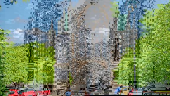 Glasgow Cathedral and the statue of David Livingstone surrounded by greenery. 