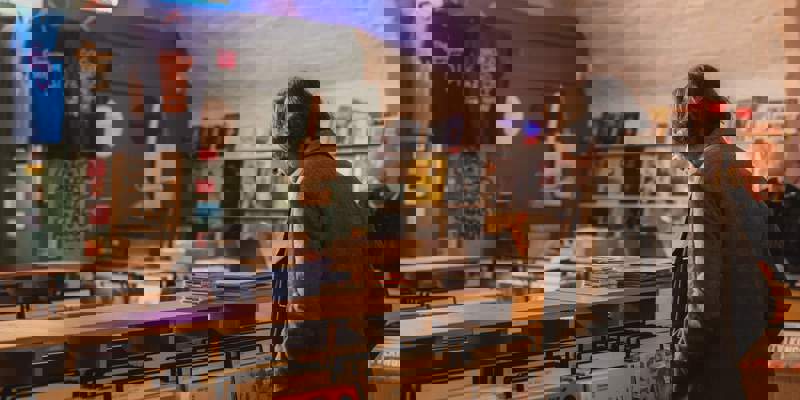 A man browses records in Monorail Music, a brightly lit record store with shelves filled with vinyl albums.