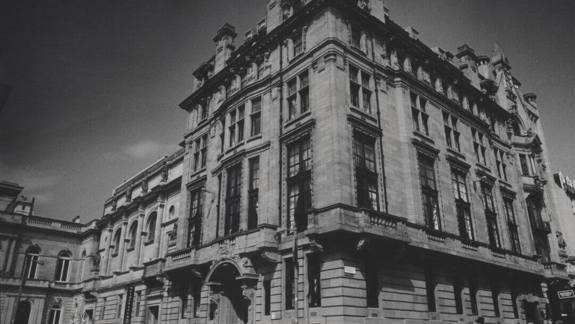 A black and white photograph of the historic, ornate Royal Conservatoire of Scotland (RCS) building in Glasgow, showing its classical stone facade.