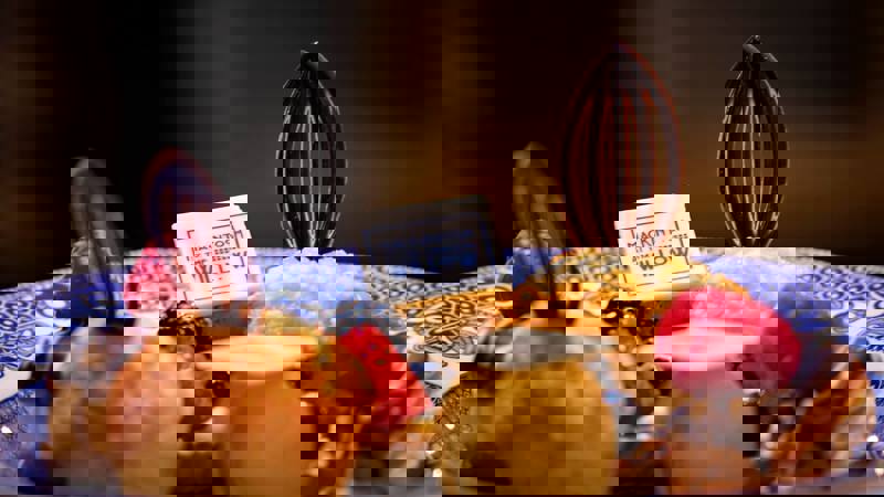 A plate with scones, jam, and intricate small cakes decorated with raspberries and chocolate on blue and white plates at the Mackintosh at the Willow.