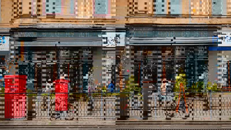 Street view of Kilmurry & Co café with outdoor seating, a bicycle parked at the railings, and a red post box in front