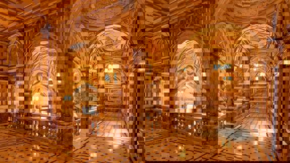 The grand interior of Glasgow City Chambers, featuring ornate marble arches, decorative ceilings, and a large, elegant staircase.