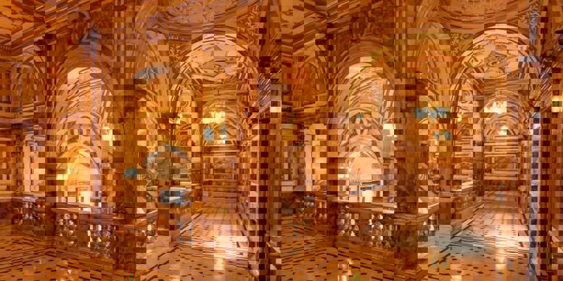 The grand interior of Glasgow City Chambers, featuring ornate marble arches, decorative ceilings, and a large, elegant staircase.