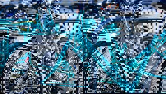 A close-up shot of several turquoise-coloured bicycles from a company called "Glasgow Bike Tours."