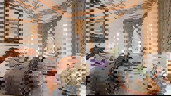 Elegant bedroom at The Alamo Guest House featuring a wooden sleigh bed, freestanding bathtub with mood lighting, and classic décor with ornate furnishings.