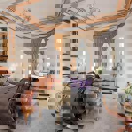 Elegant bedroom at The Alamo Guest House featuring a wooden sleigh bed, freestanding bathtub with mood lighting, and classic décor with ornate furnishings.