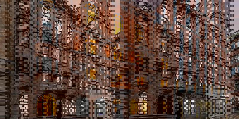 ac marriott: Street view of AC Hotel Glasgow’s exterior, blending historic red sandstone architecture with a modern brick and glass tower.