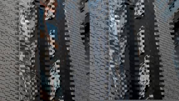 A large, mirrored sign spelling "EMPIRE" in bold, retro lettering reflects a brick building.