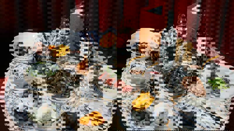 Marble table set with steak, fries, wine glasses, and condiments.