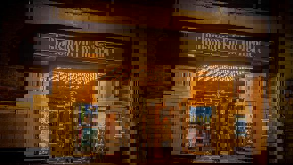 The entrance to the Glasgow Film Theatre, with a lit marquee and a person walking through the doors.