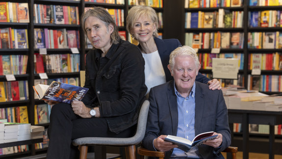 Authors and speakers at Glasgow’s Aye Write book festival posing in a bookshop with books.
