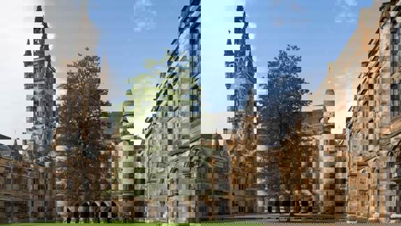 A view of a historic-looking building with a large courtyard and a clock tower.