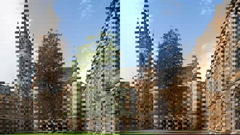 A view of a historic-looking building with a large courtyard and a clock tower.