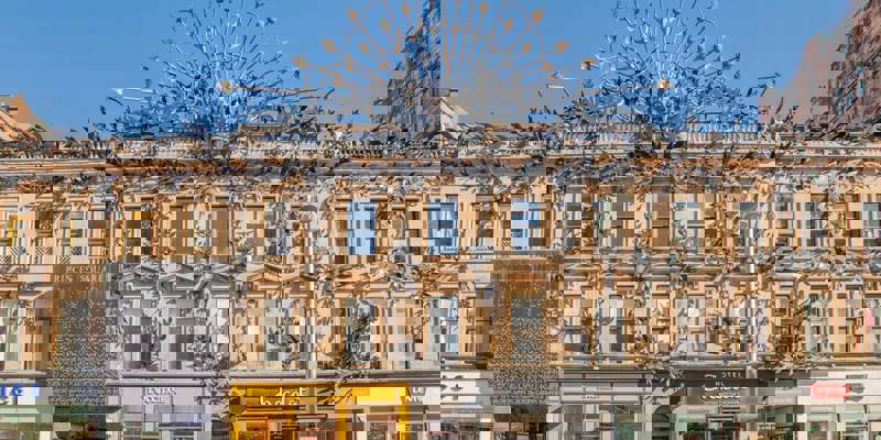 Ornate facade of Princes Square shopping center with decorative metalwork and shopfronts.