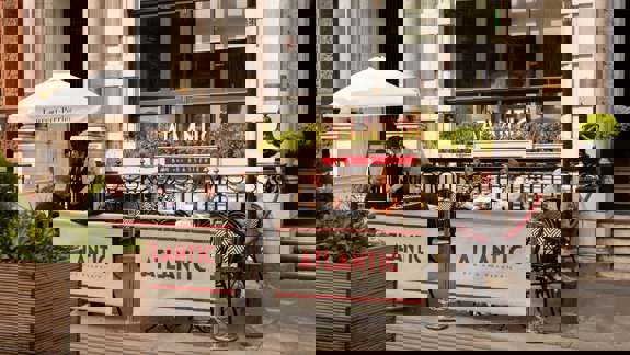 People dining at outdoor tables in front of the Atlantic Bar and Brasserie.