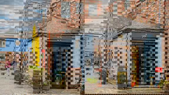 Colorful brick buildings and a small café with the number 25 in the Hidden Lane, Glasgow.